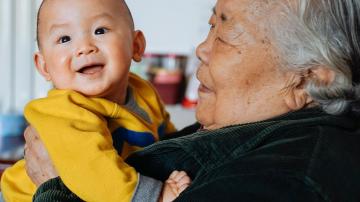 Elderly Asian woman holding grandson