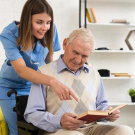 Nurse pointing to old man's book
